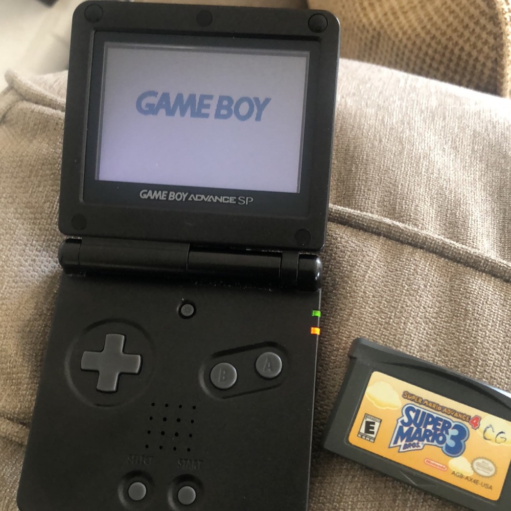 Vintage Gameboy Advance with Super Mario 3 game and charger.